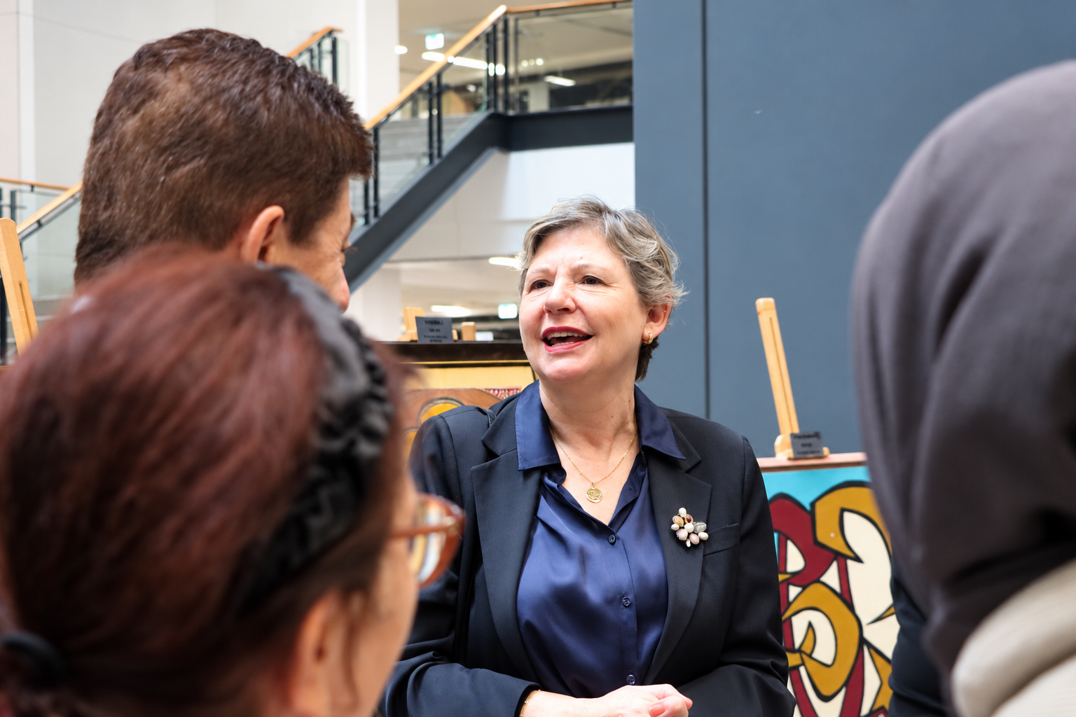 Gray haired woman speaking at an art event